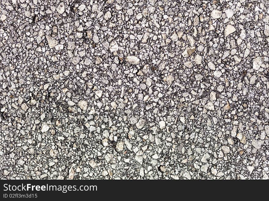 A closeup of the surface of asphalt pavement. A closeup of the surface of asphalt pavement