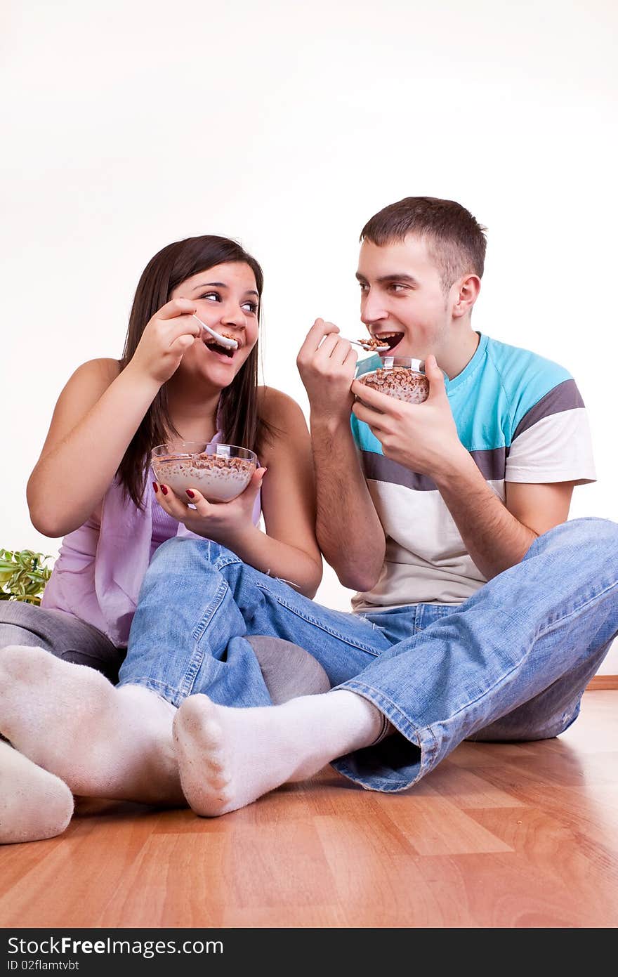 Young couple eating on the floor