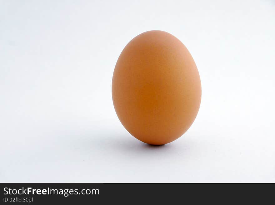 A real brown standing egg with white background. A real brown standing egg with white background.