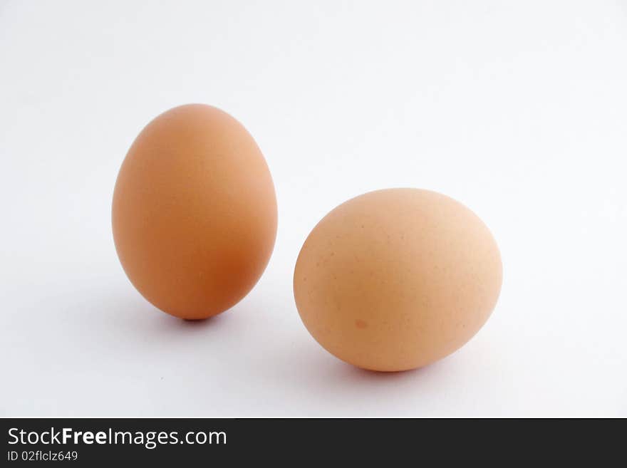 Two eggs with white background, one standing.