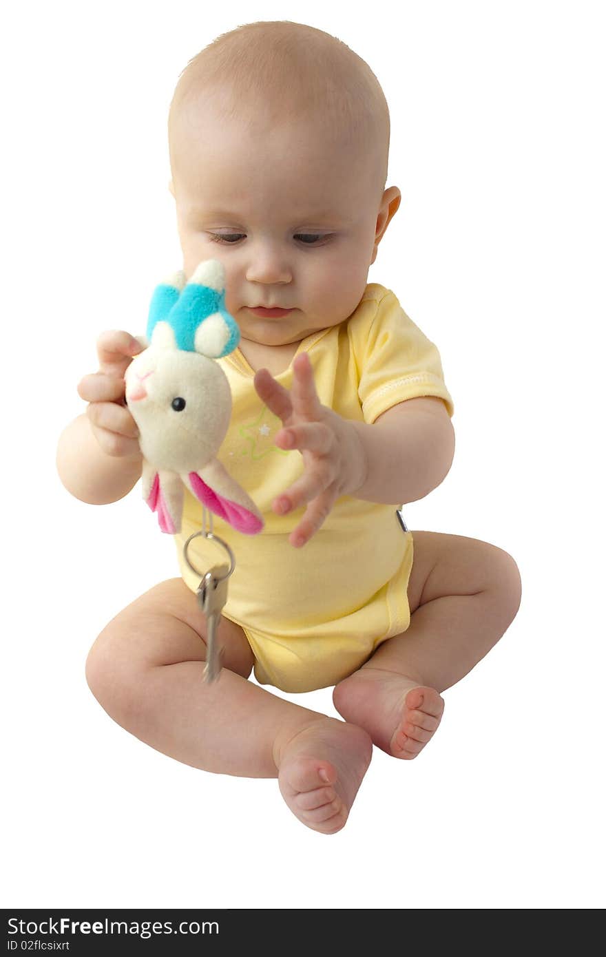 The baby sits in yellow clothes and plays with a toy on which two keys hang