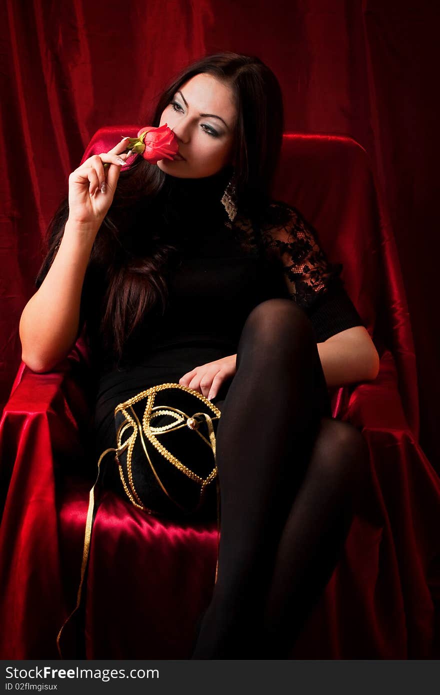 The beautiful woman with a rose on red background