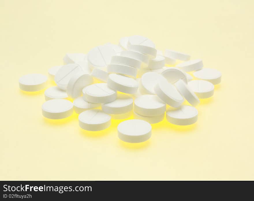 White pills on a yellow background