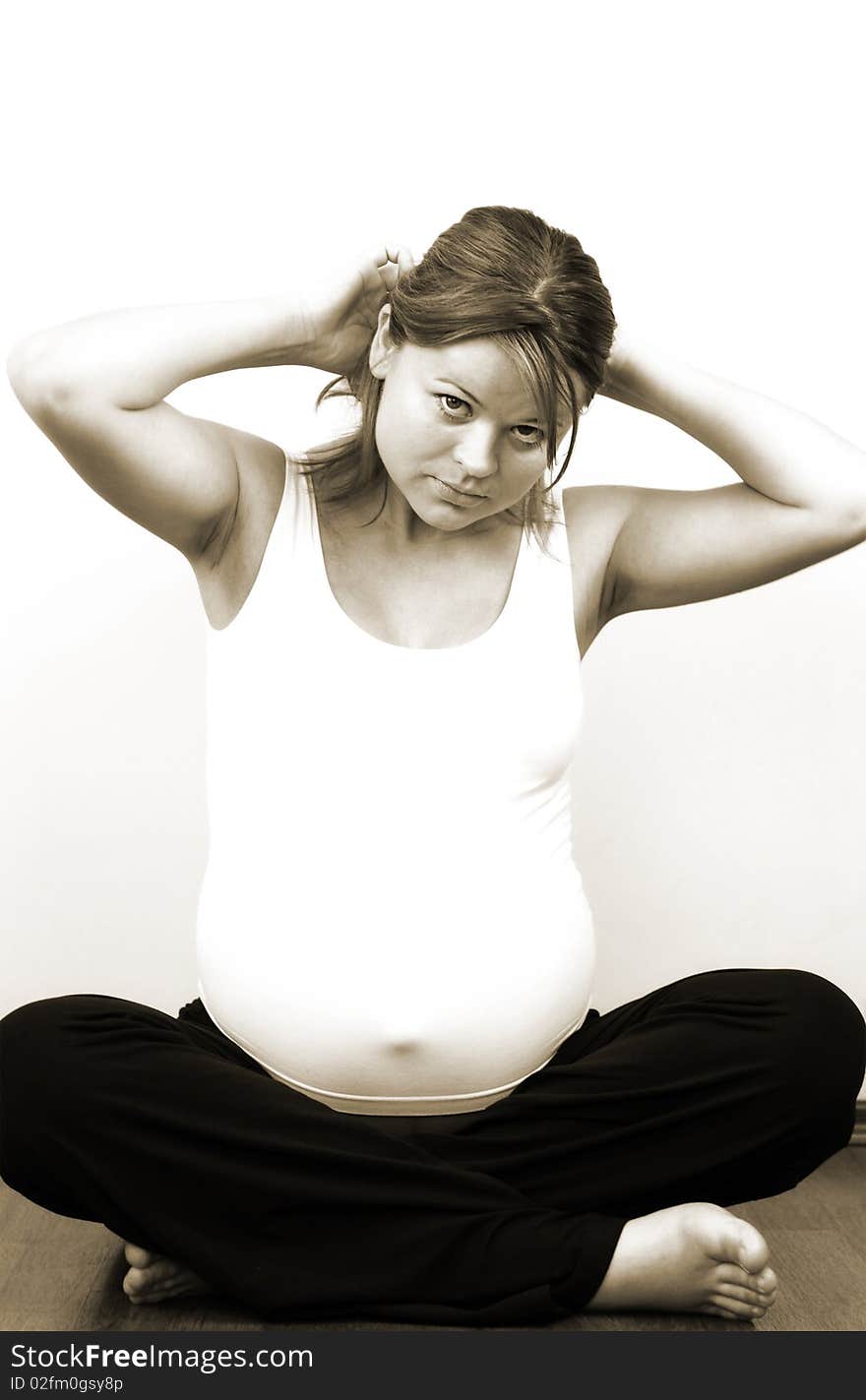 Pregnant woman arranging hair, sepia tint. Pregnant woman arranging hair, sepia tint