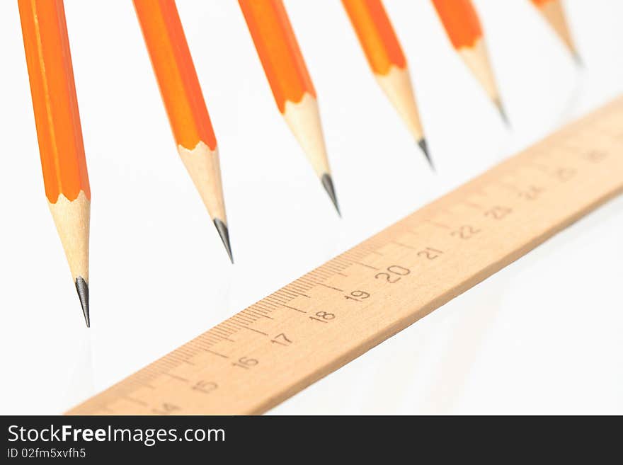 Few wooden yellow pencils in a row and ruler on white background. Few wooden yellow pencils in a row and ruler on white background