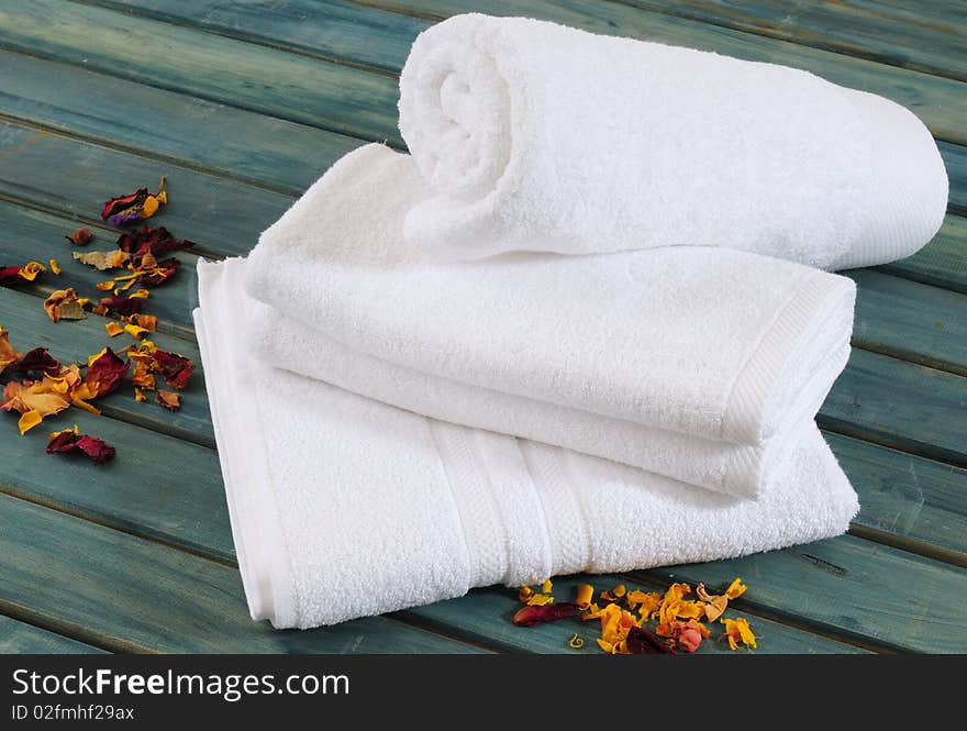 White towels with dry flowers on bench. White towels with dry flowers on bench.