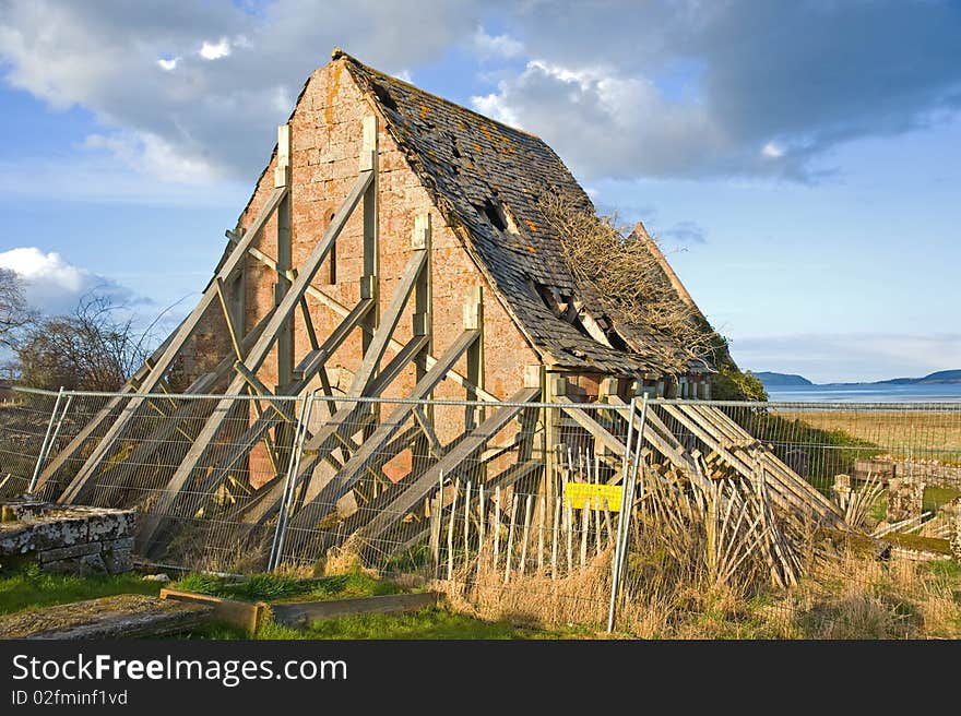 Derelict house propped up by planks.