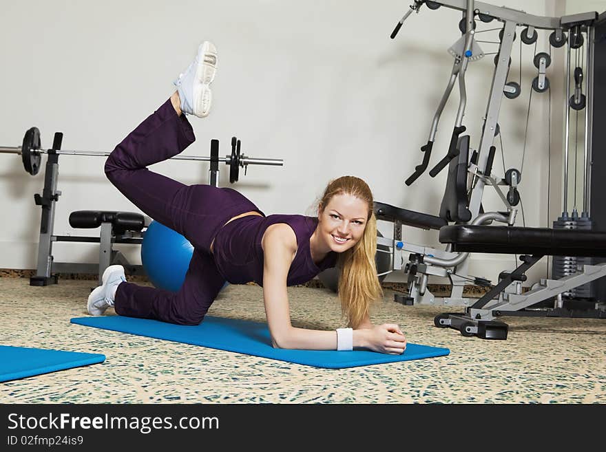 A young woman doing stretching exercises in a health club. Horizontal shot. A young woman doing stretching exercises in a health club. Horizontal shot.