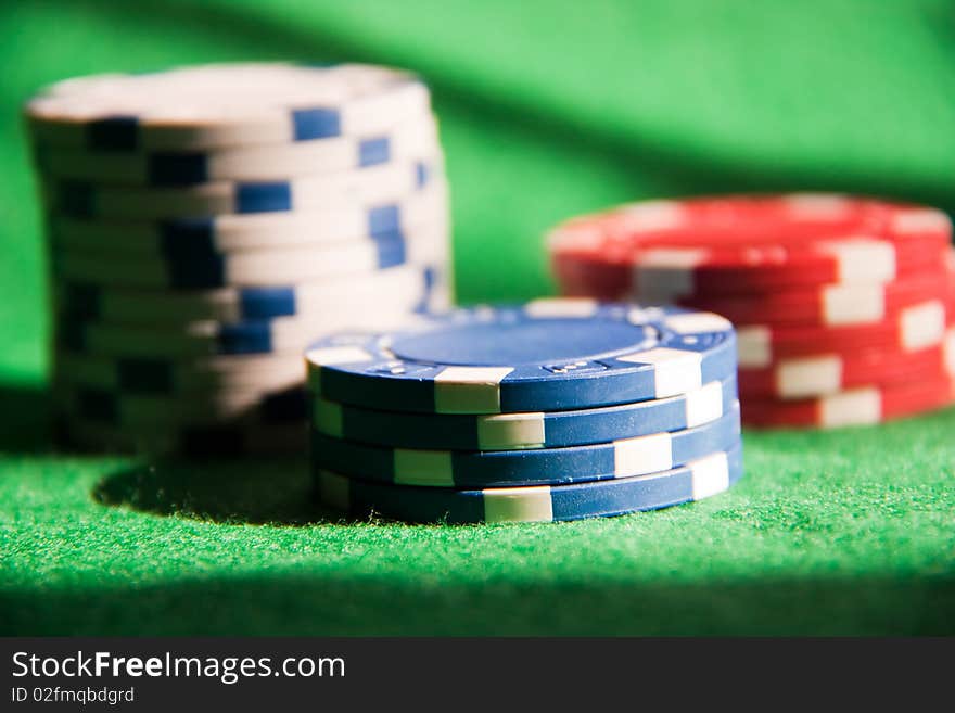 Poker chips on green on green background.