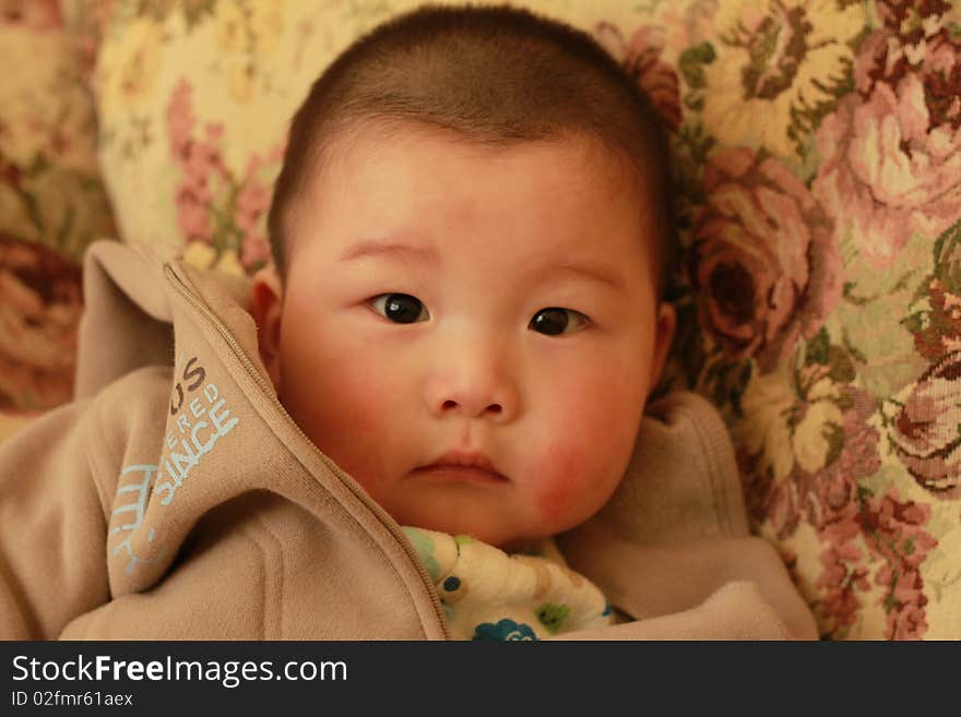 Lovely Chinese baby sitting in a chair. Lovely Chinese baby sitting in a chair