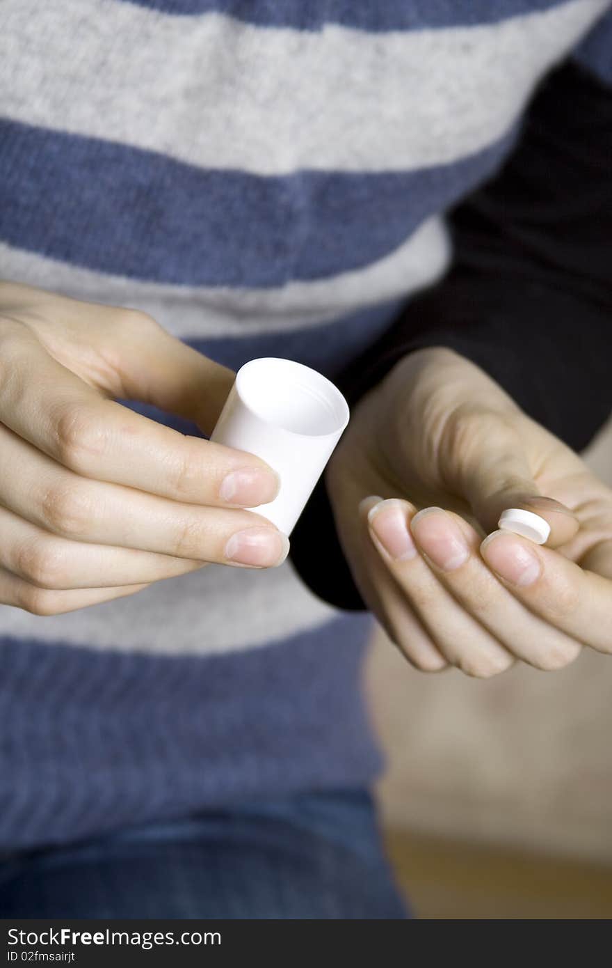 Against the background of a striped vest young white girl. In one hand the bank the other drugs in the tablet white. Pills. Against the background of a striped vest young white girl. In one hand the bank the other drugs in the tablet white. Pills