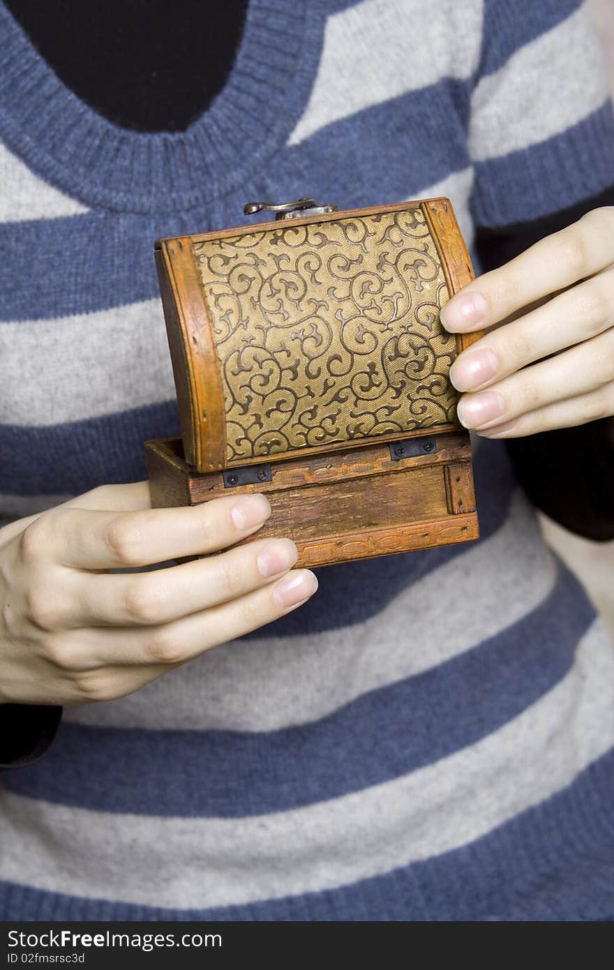 Hands holding a decorative wooden box