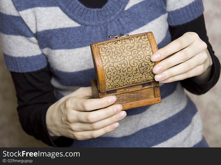 Hands holding a decorative wooden box