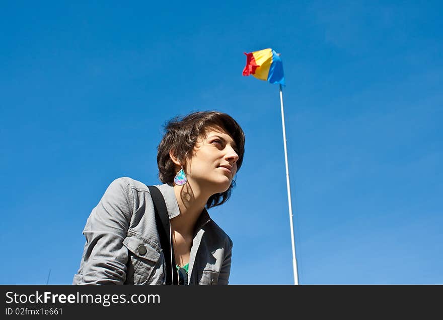 Young girl smiling with the Romanian flag in the background