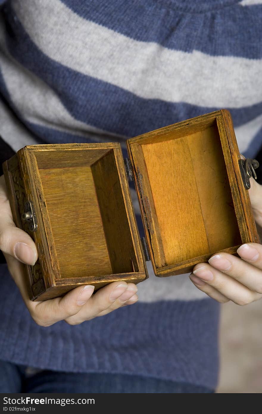 Hands of a young girl holding a decorative wooden box. Secret. Hands of a young girl holding a decorative wooden box. Secret