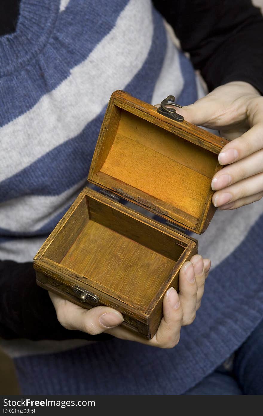 Hands of a young girl holding a decorative wooden box. Secret. Hands of a young girl holding a decorative wooden box. Secret