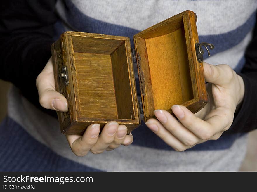 Hands holding a decorative wooden box