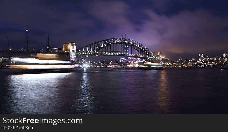 Sydney harbor bridge at dark with ship passing