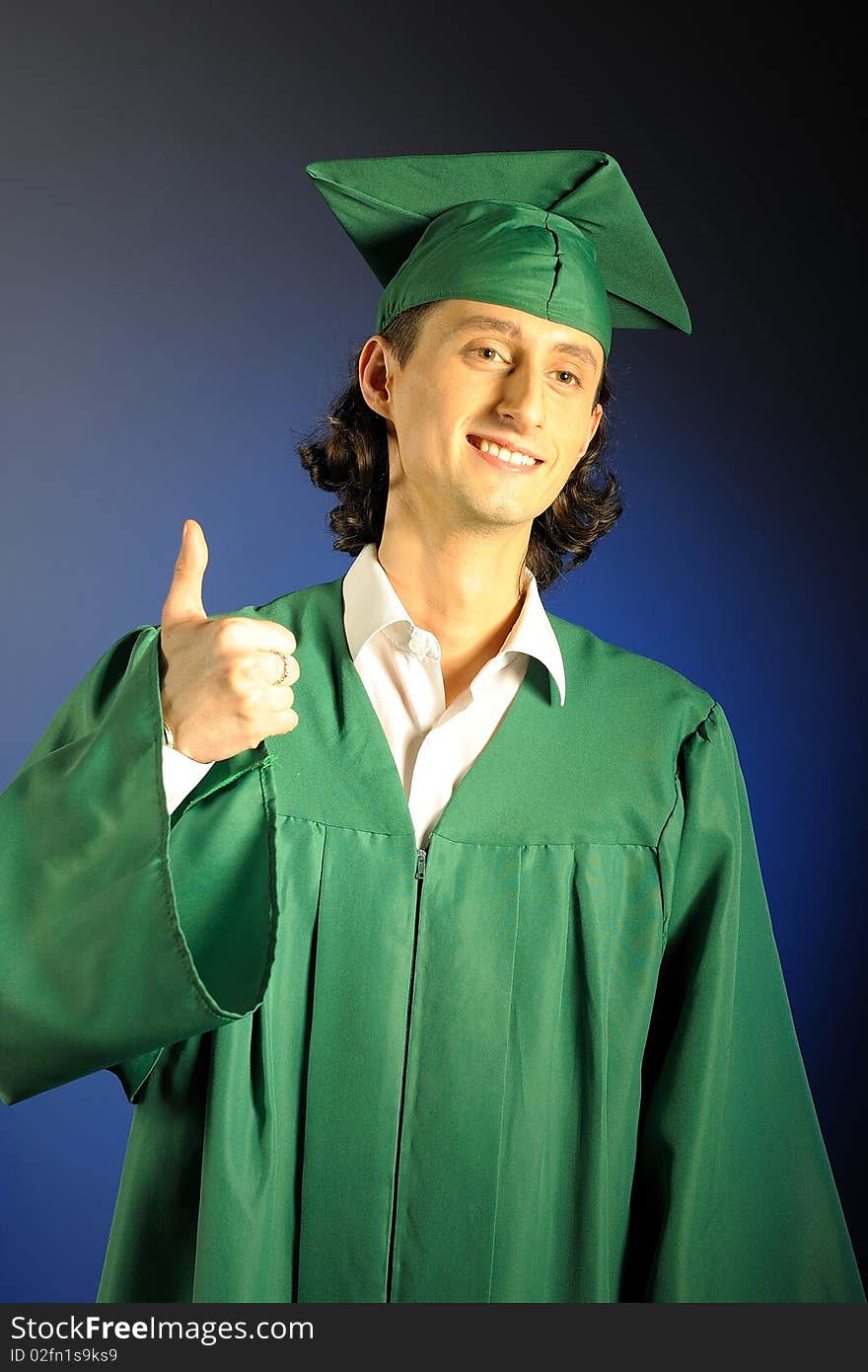 Portrait of a succesful man on his graduation day in green clothes and a hat