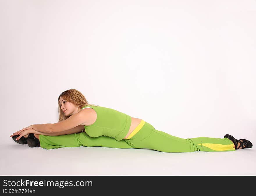 Beautiful young blonde woman doing the splits, smiling, white background. Beautiful young blonde woman doing the splits, smiling, white background