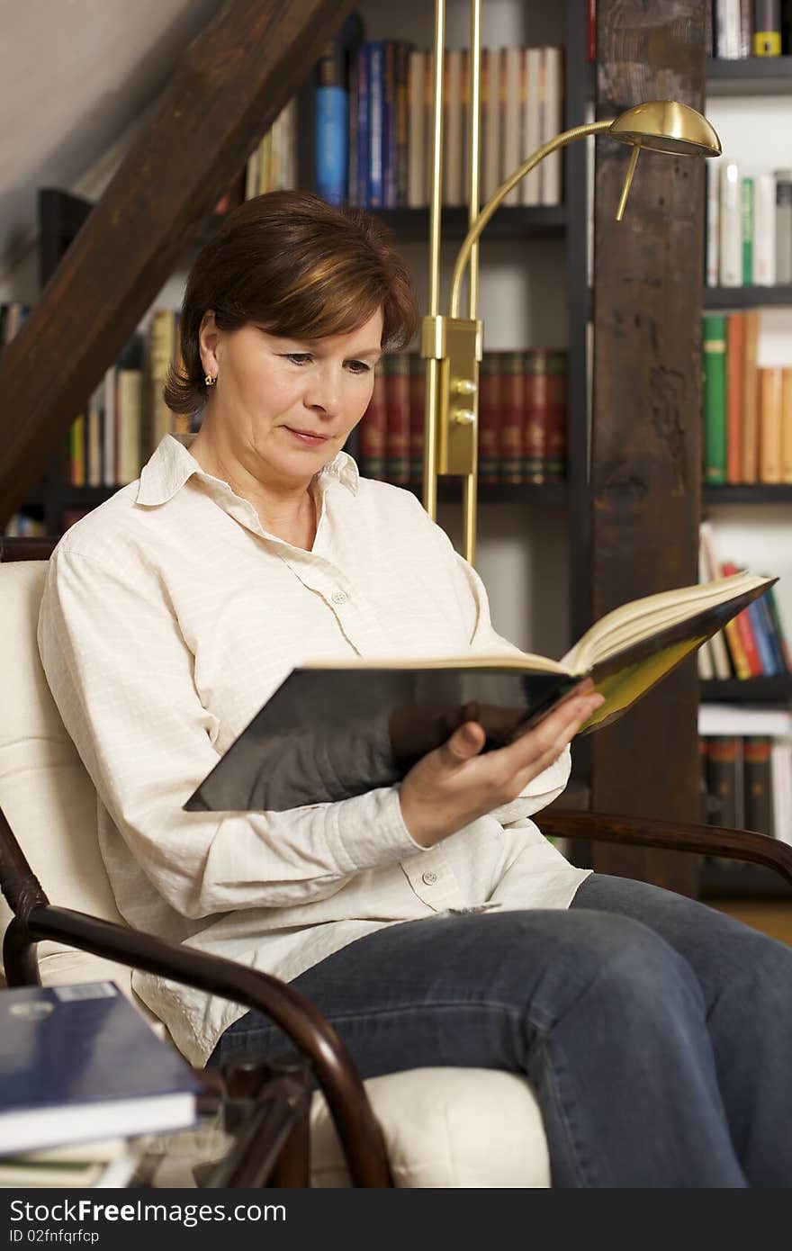 Pretty senior woman sitting and reading a book