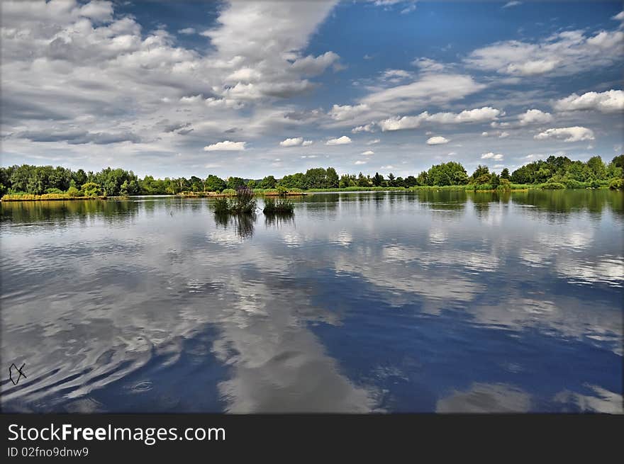 Summer pond under blue sky background