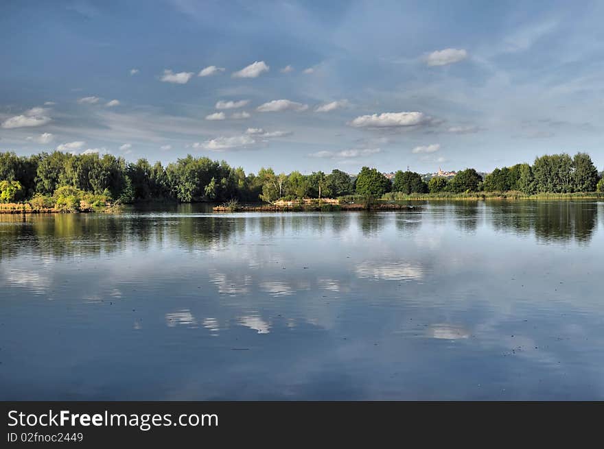 Summer pond under blue sky background