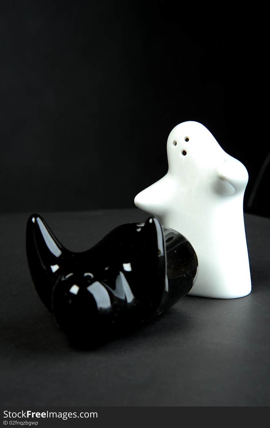 Porcelain saltcellar and pepperpot on grey background