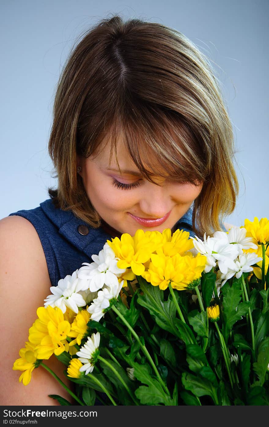 Young cute pregnant girl with bouquet of flowers