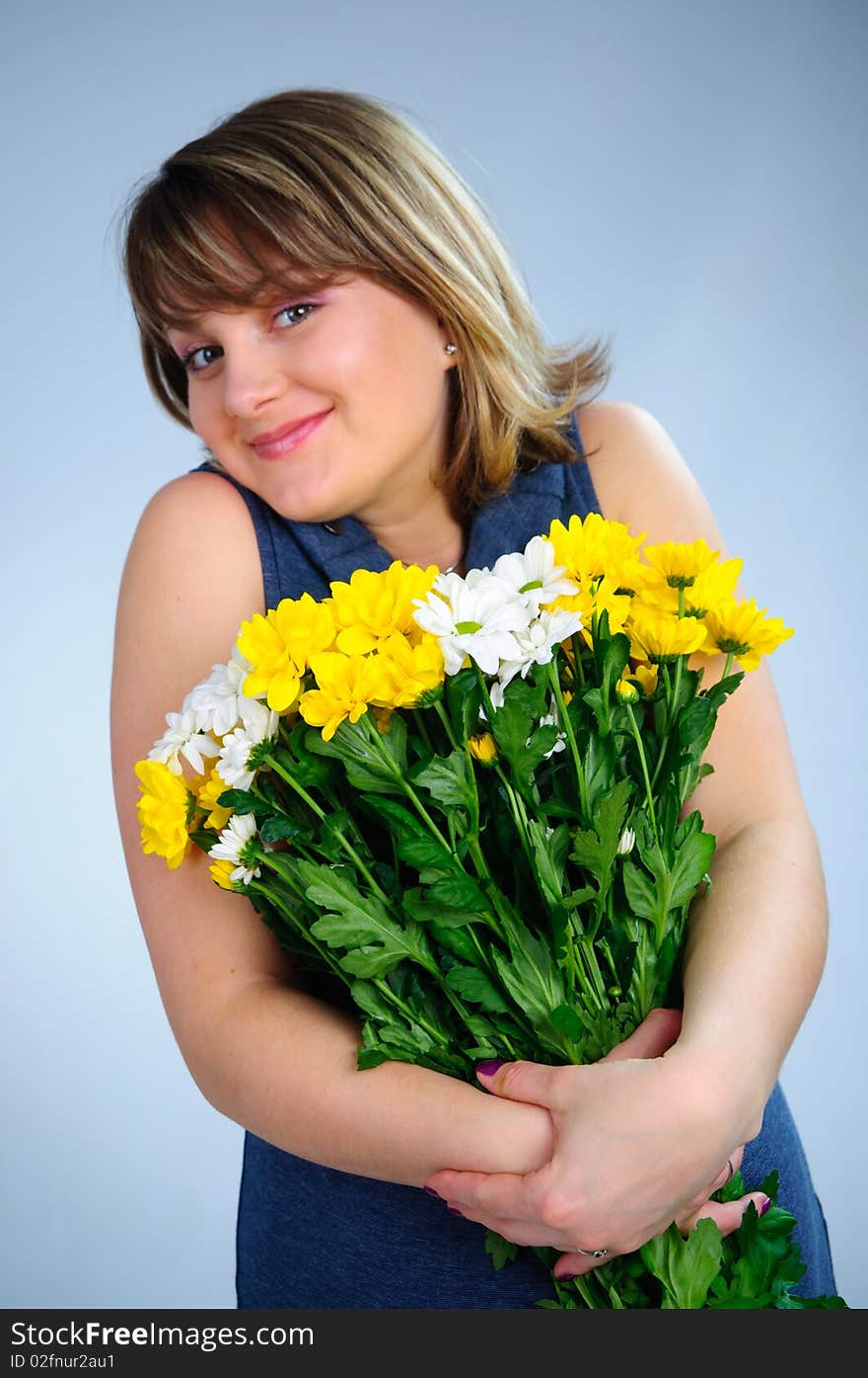 Young cute pregnant girl with bouquet of flowers