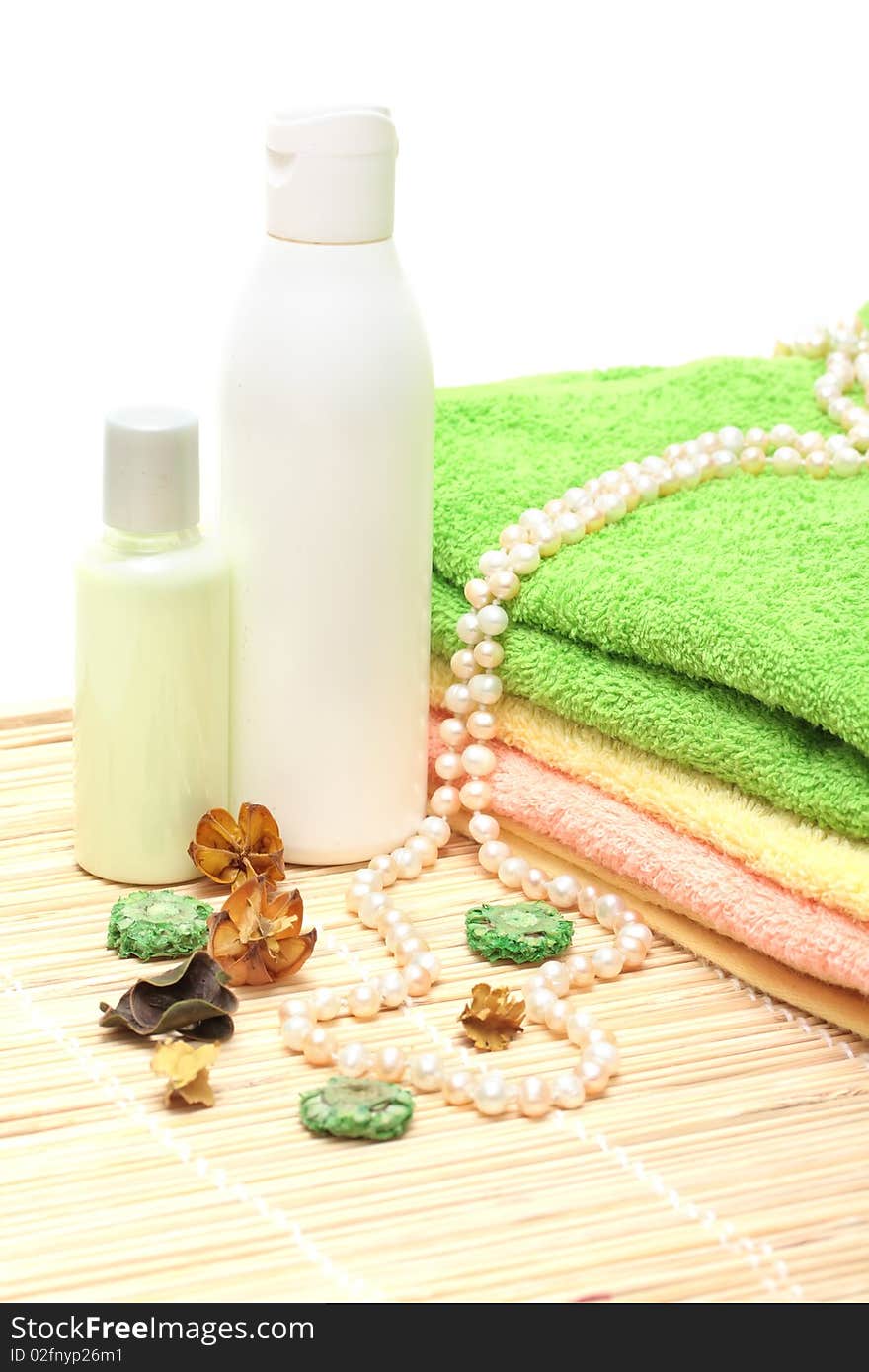 Shampoo, cream, towels, a pearl beads on a white background. Shampoo, cream, towels, a pearl beads on a white background