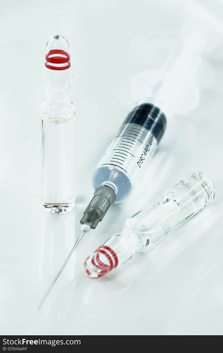 Close-up of Ampules and Syringe with soft reflection.