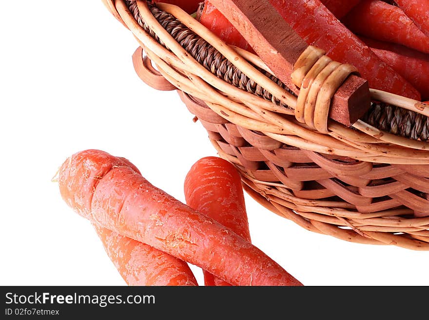 Carrot crop in a wattled basket on a white background.