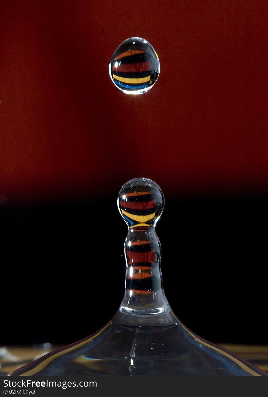 Close-up/Macro shot of drop of water with colorful stripes in drops' reflection. Close-up/Macro shot of drop of water with colorful stripes in drops' reflection