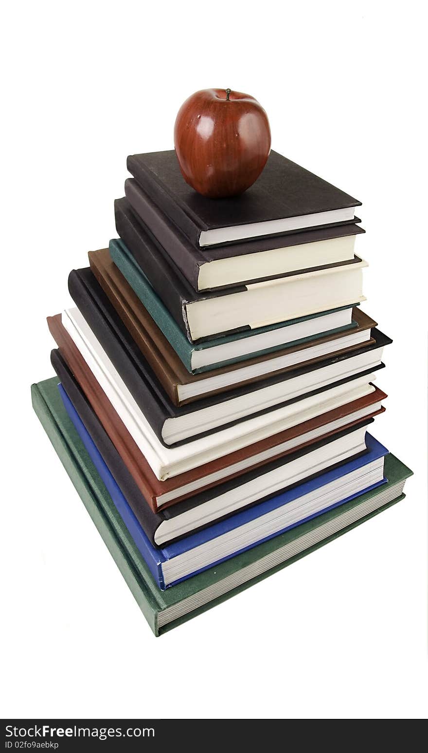 Pile of text books & apple isolated against white