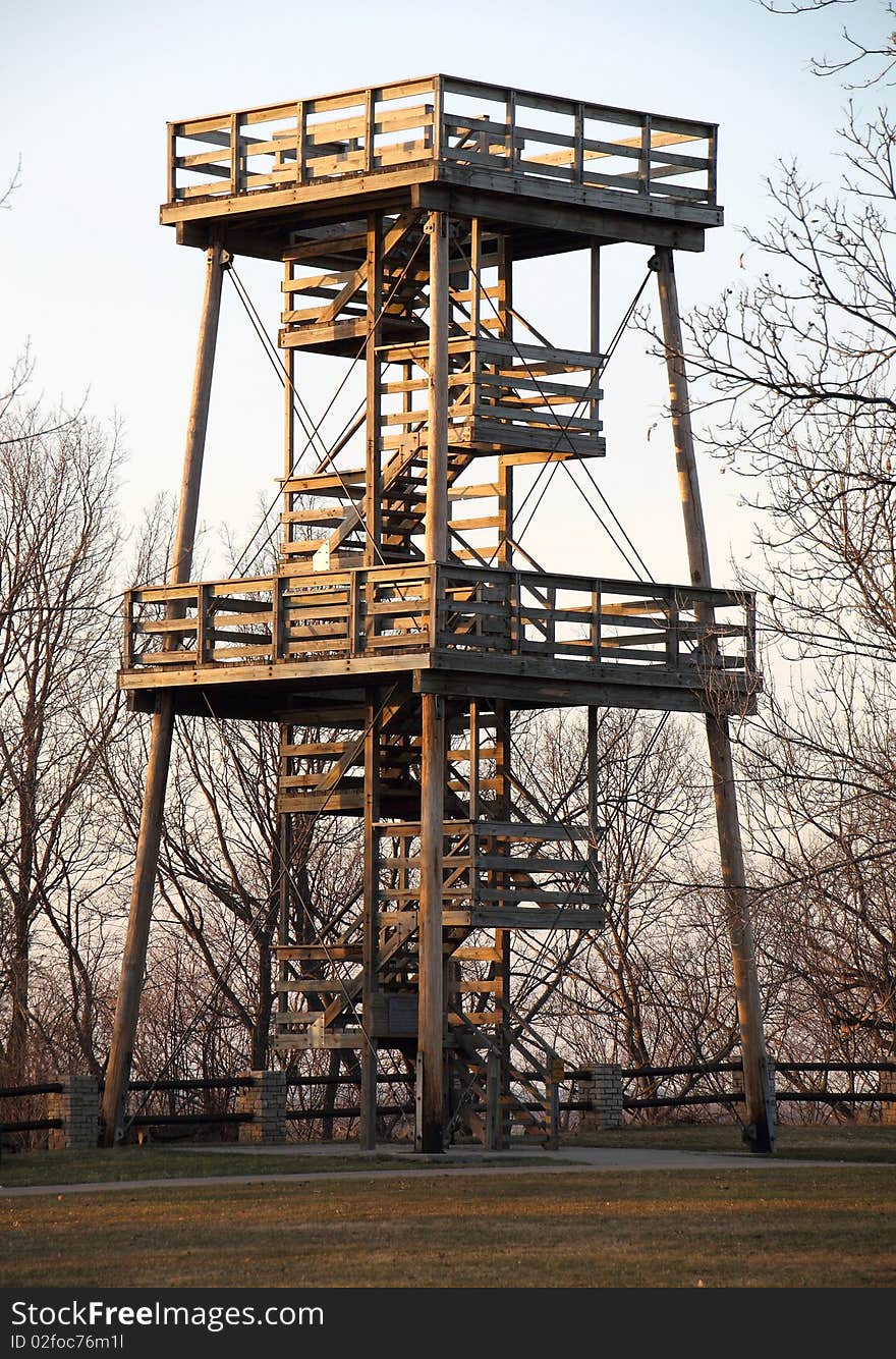 A huge fire watch tower or ranger station overlooks hundreds of acres of forest.