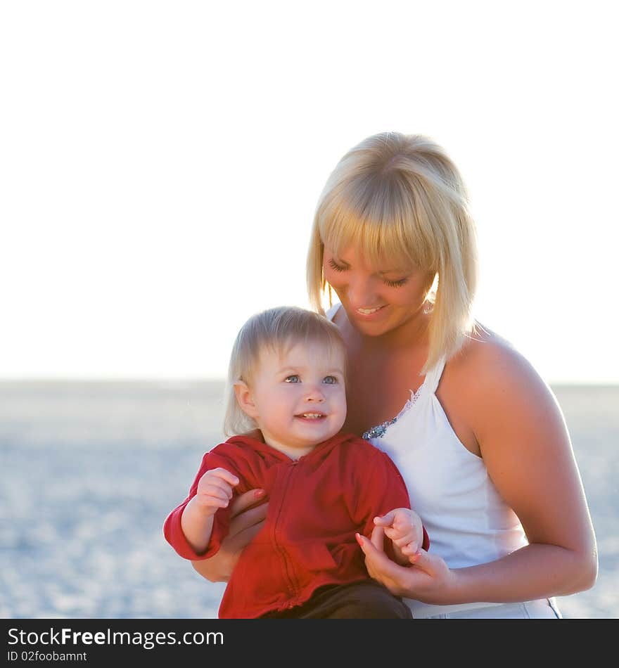 Mother and daugter on the beach in sunset light. Mother and daugter on the beach in sunset light