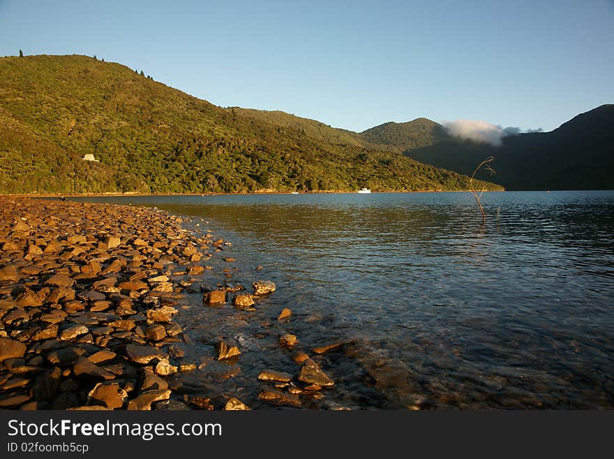 Golden sunlight on stoney foreshore.