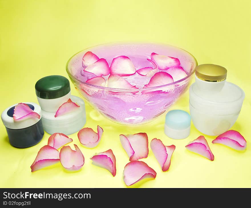 Spa bowl with pink water with rose petals and cremes. Spa bowl with pink water with rose petals and cremes