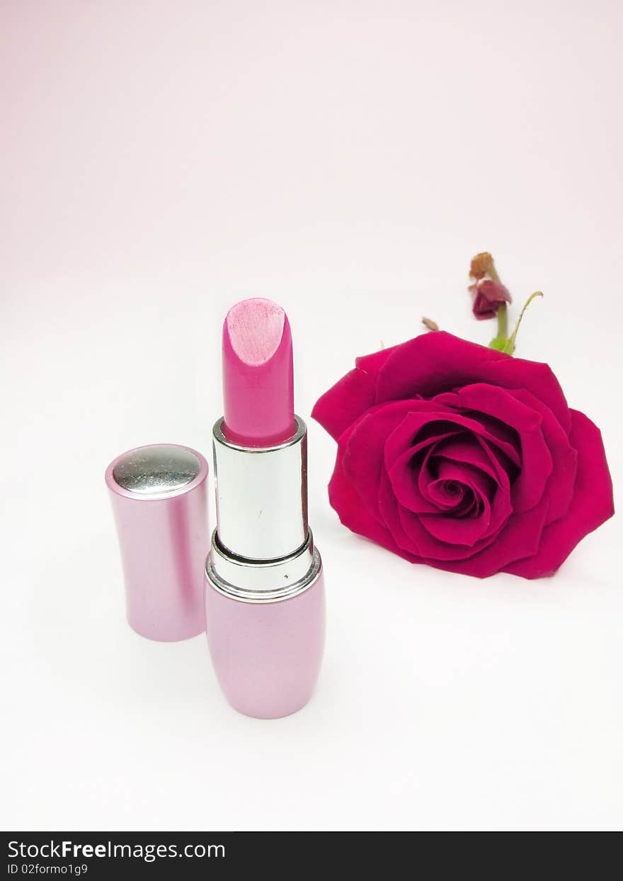 Pink lipstick with rose on background