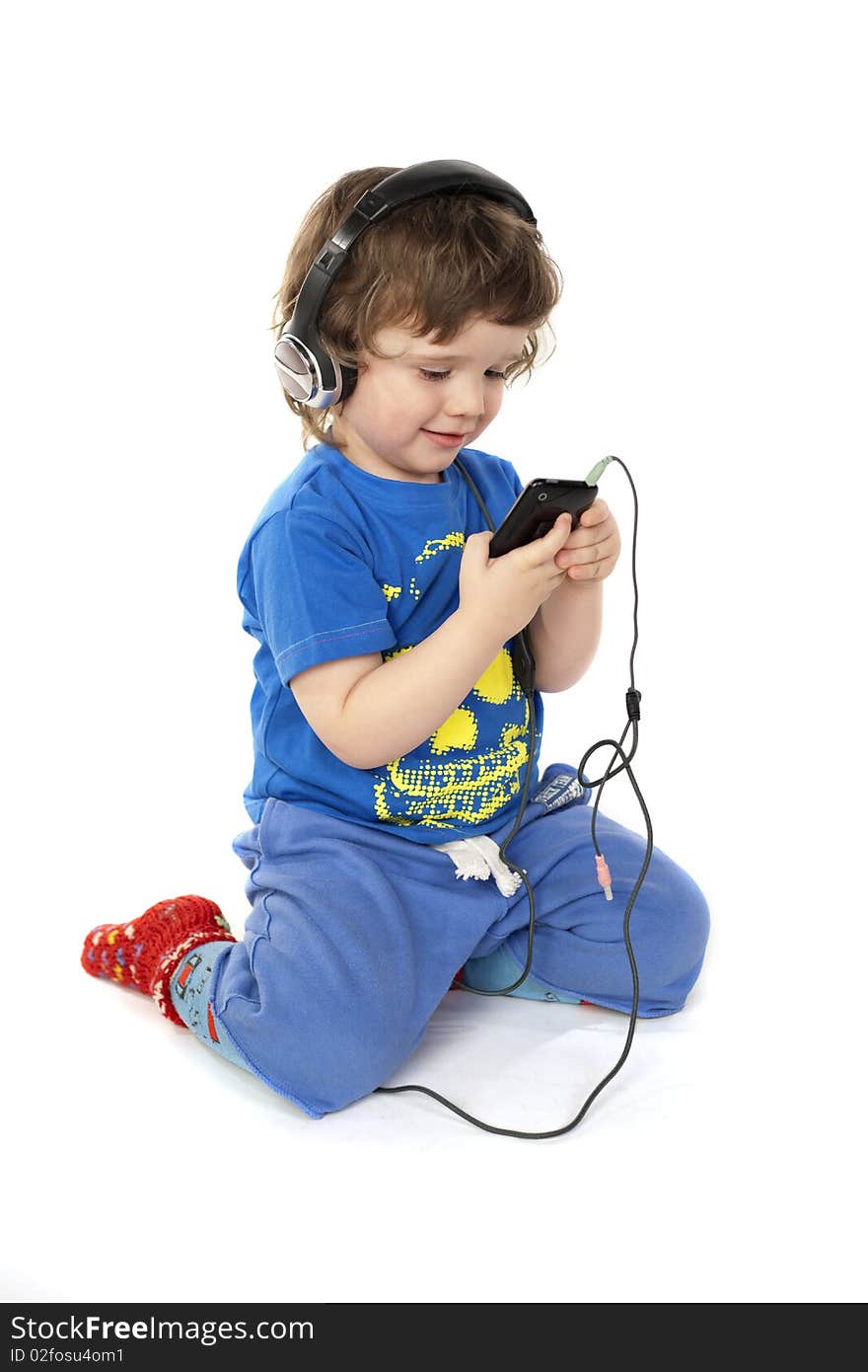 Cute child with headphones and a Mp3 player in hands. Cute child with headphones and a Mp3 player in hands