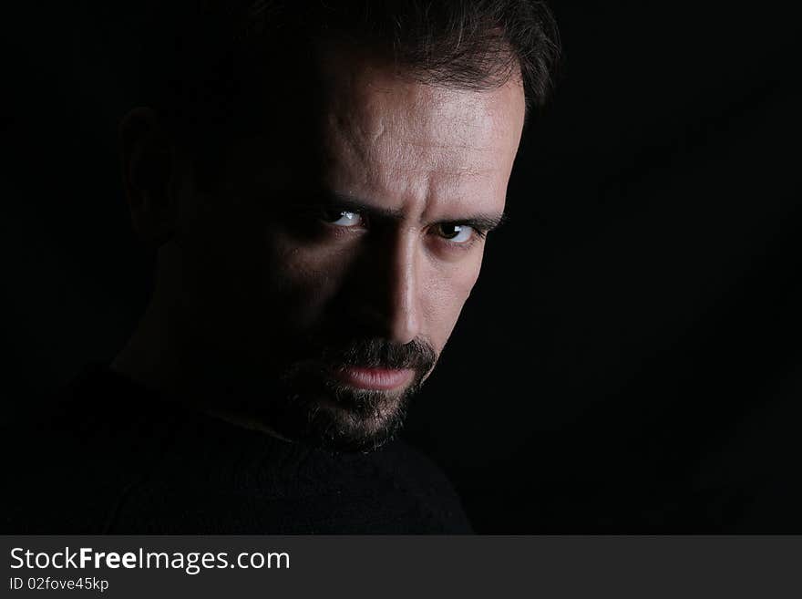 A charismatic man standing in front of a black background. A charismatic man standing in front of a black background