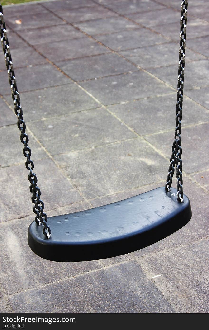 Empty dark sturdy swing on a playground, isolated. Empty dark sturdy swing on a playground, isolated