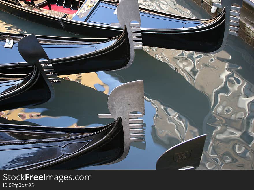 The gleaming prows of gondolas on the still surface of the canal. The gleaming prows of gondolas on the still surface of the canal