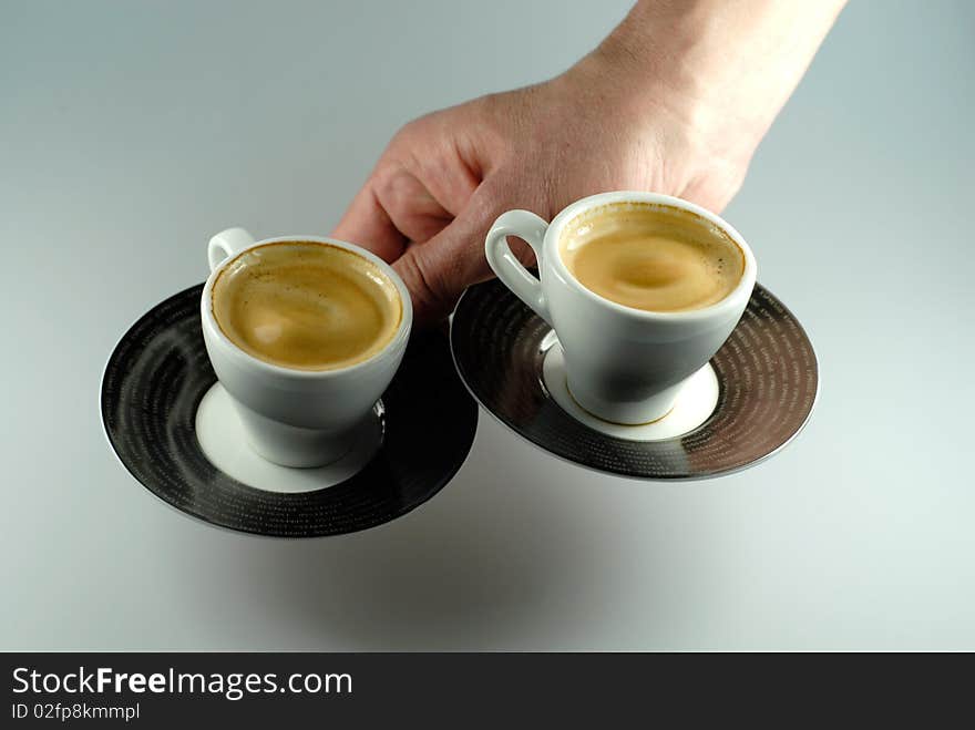 Hand serving two espresso cups