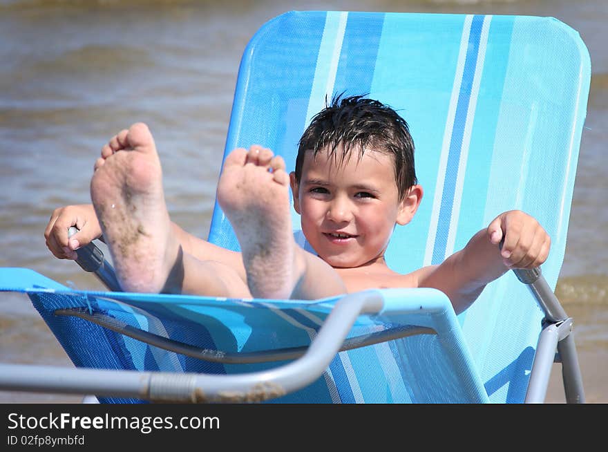 Cute little boy relaxing on the beach. Cute little boy relaxing on the beach