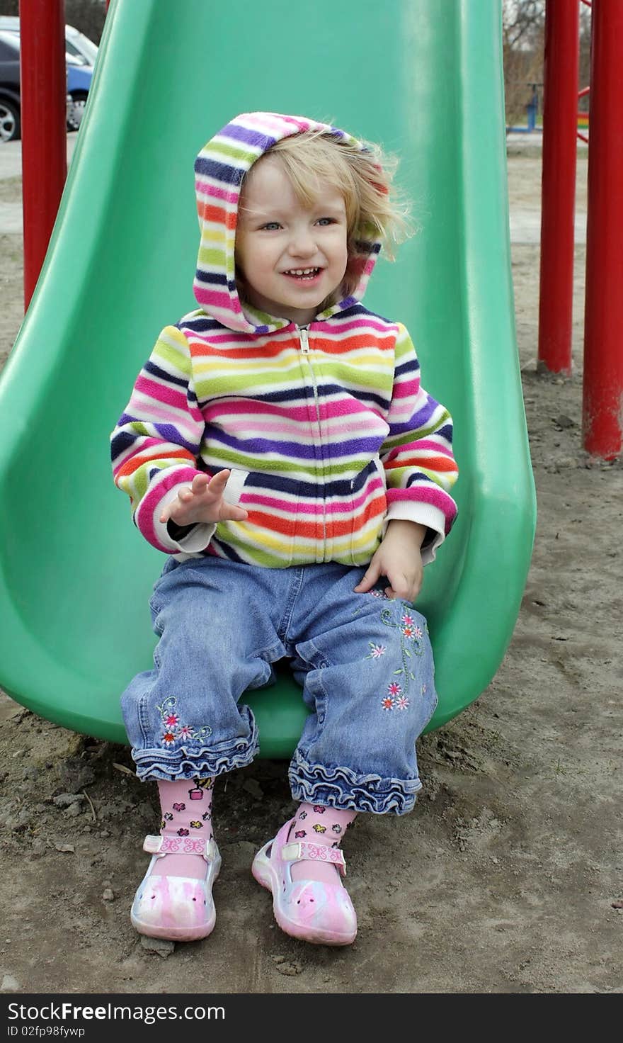 A child in a striped blouse drives off the hill. A child in a striped blouse drives off the hill