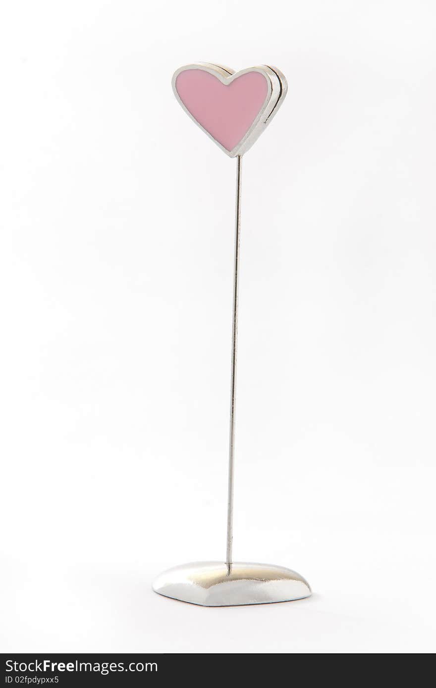 A pink heart shape metal notes holder. A pink heart shape metal notes holder