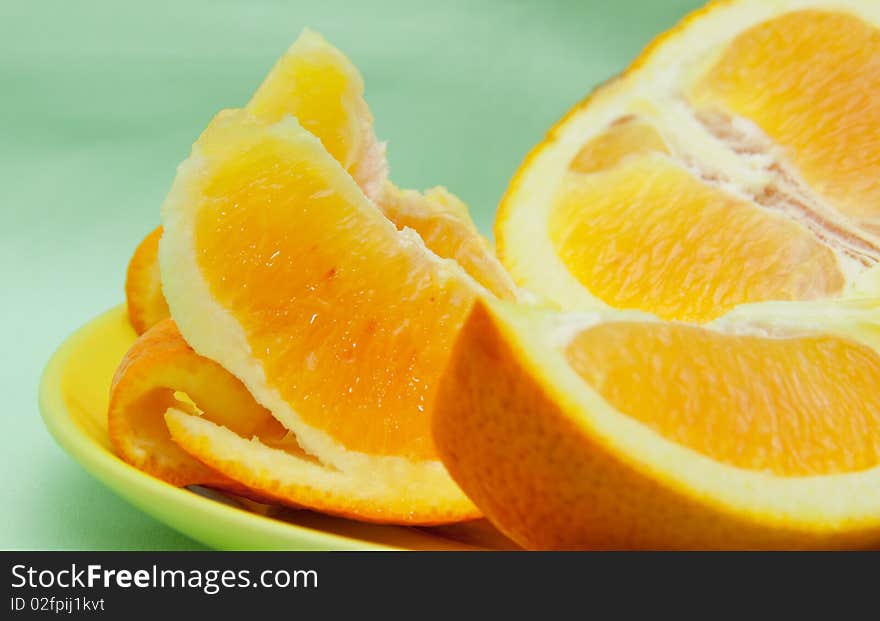 Segments of juicy orange on yellow plate. Segments of juicy orange on yellow plate