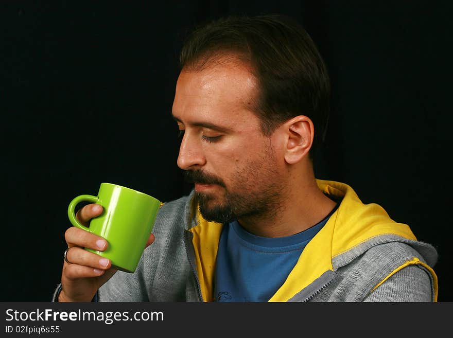 While the image of a charismatic man drinking tea. While the image of a charismatic man drinking tea